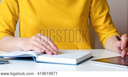A Woman Writes Down Information With A Pen In A Diary