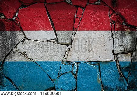National Flag Of Luxembourg Depicting In Paint Colors On An Old Stone Wall. Flag  Banner On Broken  