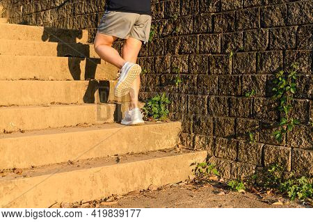 Cropped View Of Fitness Runner Woman Training Herself By Running Up Steps On Staircase In Urban Stre