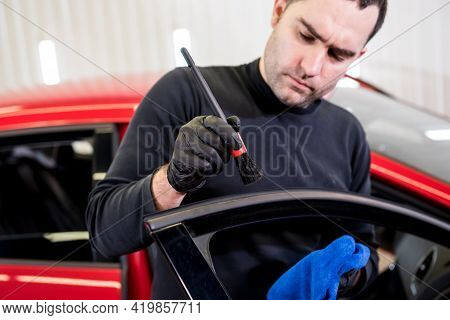 Car Service Worker Cleans Interiror With Special Brush