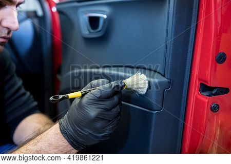 Car Service Worker Cleans Interiror With Special Brush