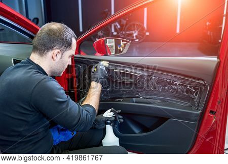 Car Service Worker Cleans Interiror With Special Brush