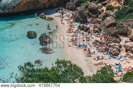 Mallorca, Spain: May 22, 2018: Calo Del Moro Beach, Santanyi. Crowded Mediterranean Beach, Clear Tur