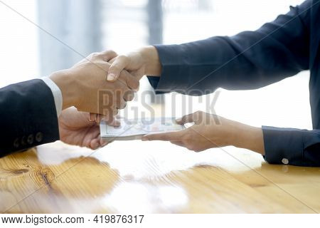 Businessman Shake Hand With Officer And Hold The Cash