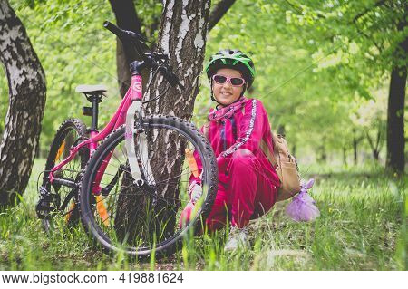 Konstantinovka, Ukraine - May 08, 2021: Little Girl In Pink Clothes Posing With A Pink Bike.
