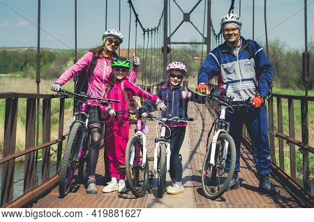 Konstantinovka, Ukraine - May 8, 2021: Happy Family With Bicycles On The Old Iron Bridge