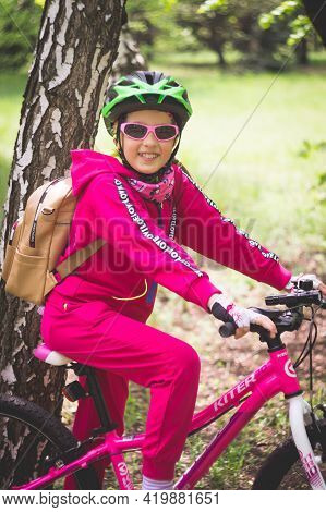 Konstantinovka, Ukraine - May 08, 2021: Little Girl In Pink Clothes Posing With A Pink Bike.