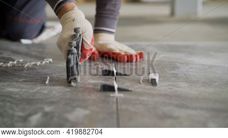 Laying Tiles On The Floor. The Man Is Installing Ceramic Tiles. For Fixing At The Same Distance. Ins