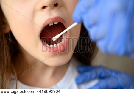 Coronavirus Test And Mouth, Kid Opens Mouth For Covid-19 Diagnostics. Doctor Or Nurse Holds Swab For