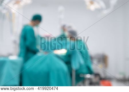 Blurred Image Background Of Medical Team Performing Surgical Operation In Operating Room. An Operati