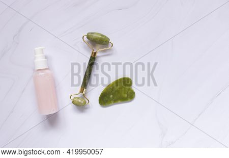 Jade Guasha Scraper Cupping Roller Facial Massager And Cosmetic Cream. The Concept Of Self-care. Zer