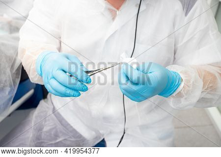 Dentist Doctor Holding Surgical Forceps, Suture Needle, Stapling Material