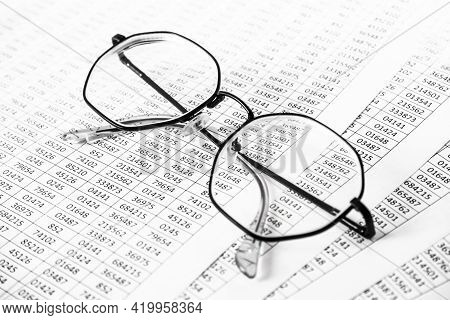 Worksheets Or Reports Showing Figures Through Eye Glasses. Closeup Glasses On Financial Report. Acco