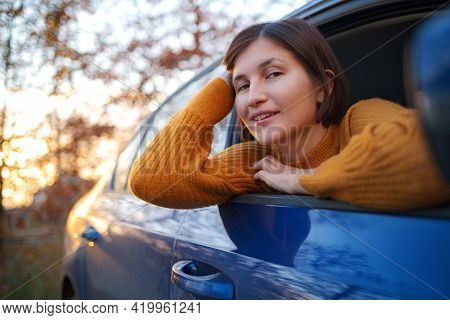 Cheerful Asian Woman In A Car On Sunset