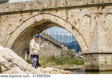 Visegrad, Bosnia, August 16, -  Bosnia And Herzegovina, 2014: Fisherman At Mehmed Pasa Sokolovic Bri