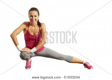 smiley young sportswoman doing stretching exorcises. isolated on white background