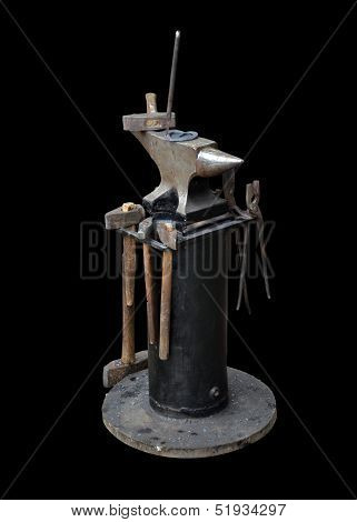 Isolated Blacksmith Anvil On The Frame And A Set Of Blacksmith Tools