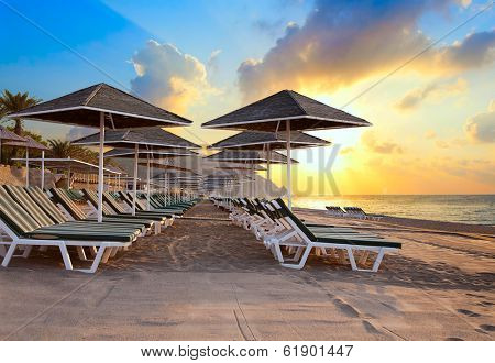 Beach chairs and umrellas at dawn on the sea