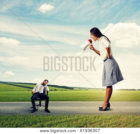 tired man and emotional woman with megaphone on the road