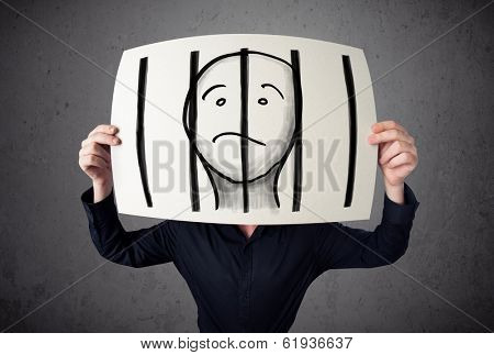 Businessman holding a paper with a prisoner in jail behind the bars on it in front of his head