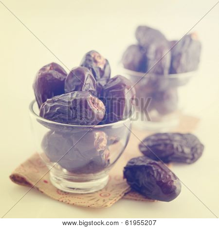 Dried date palm fruits or kurma, ramadan food which eaten in fasting month in vintage retro effect.