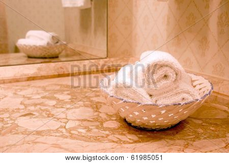 Towels in luxury bathroom with beige marble counter