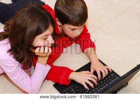 Portrait of brother and sister looking into computer