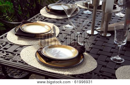 Table setting on a patio table with plates and martini glasses