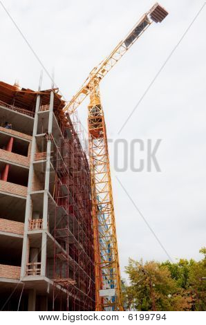Building With Construction Crane And Scaffold