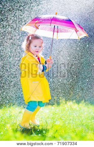 Funny Toddler With Umbrella Playing In The Rain