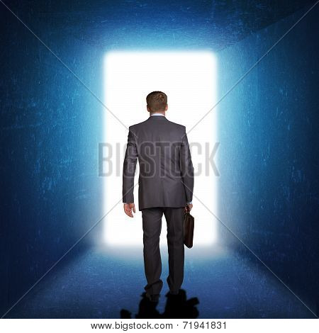 Businessman in suit with briefcase stepping through door