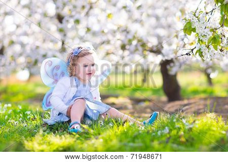 Happy Toddler Girl In Fairy Costume In Spring Apple Garden