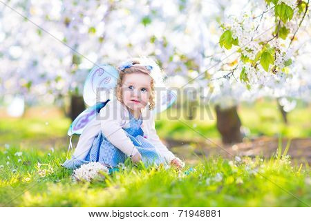 Curly Toddler Girl In Fairy Costume Playing In Fruit Garden