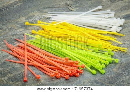 self-locked plastic zip cable ties in different colors over slate rock background