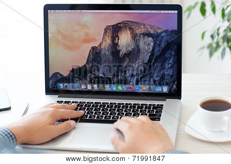 Man Sitting At The Macbook Pro Retina With Osx Yosemite On The Screen In The Office