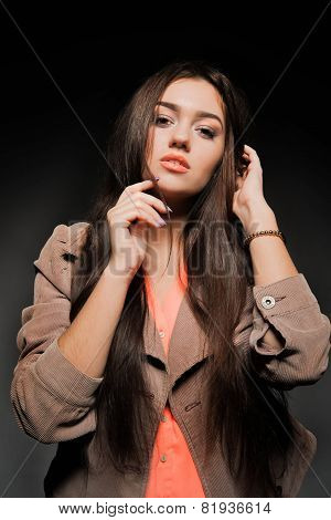 Beautiful brunette with long hair on a dark background