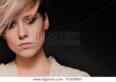 Blonde girl with a short stylish haircut on a dark background