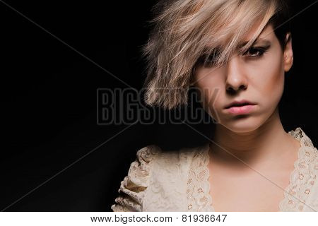 Blonde girl with a short stylish haircut on a dark background
