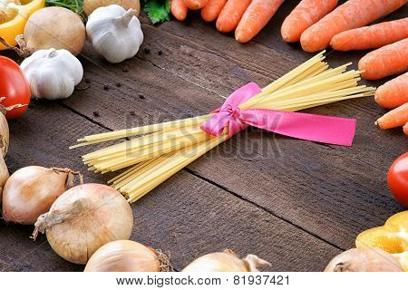 Pasta and vegetables on wooden table background