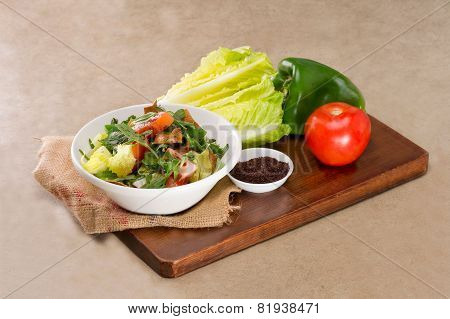 Plate of traditional Arabic salad fattouch on a wooden plate