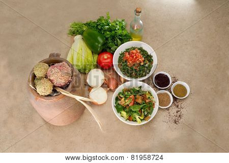 Plates of traditional Arabic salad fattouch and tabbouleh on a rustic background