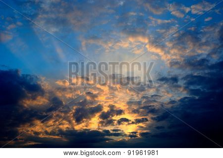 golden sunset rays in clouds after rain