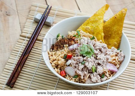 Spicy instant noodle with minced pork on wood background