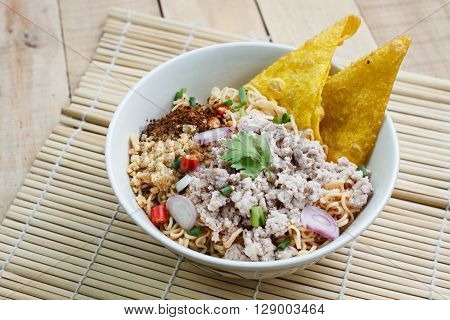 Spicy instant noodle with minced pork on wood background