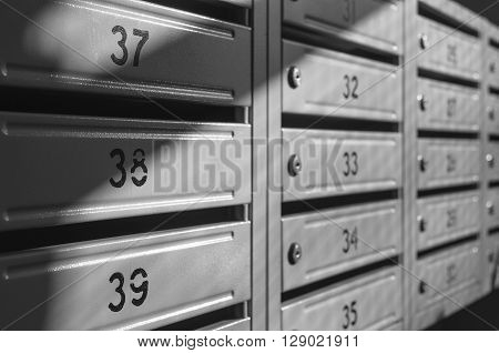 grey metallic mailbox array inside apartment houses