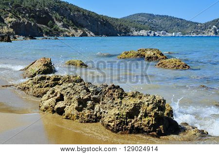 detail of the Aigues Blanques beach in the Mediterranean Sea, in Ibiza Island, Spain, and Cala de Sant Vicent in the background