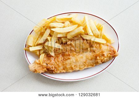 Traditional english meal - deep fried fish haddock with chips served in local restaurant in Hastings England.