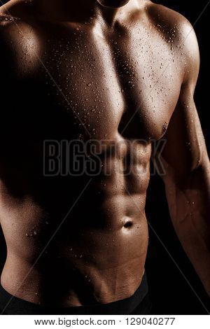 Muscular And Fit Young Bodybuilder Fitness Male Model Posing Over Black Background. Perfect Fitness