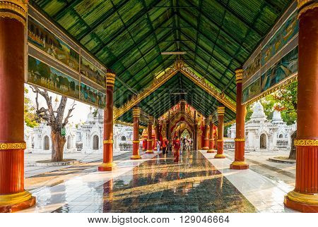 Mandalay Myanmar - January 13 2012: People at the entrance of the Kuthodaw Paya temple known olso as 'the world's biggest book'.