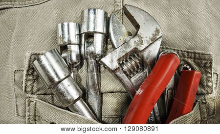 Several tools on a denim workers pocket
